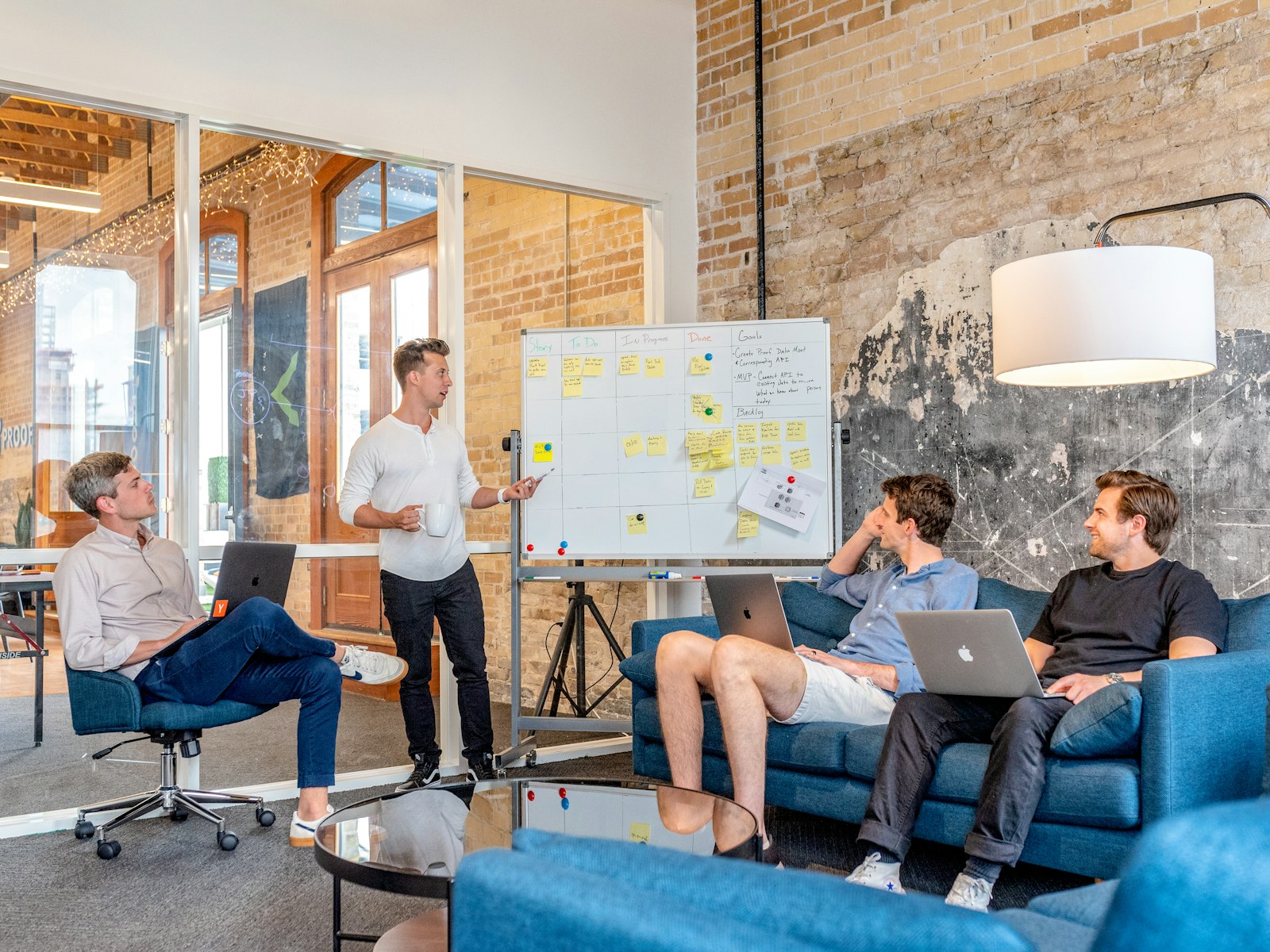 Consultant presenting a plan on a whiteboard to a seated team