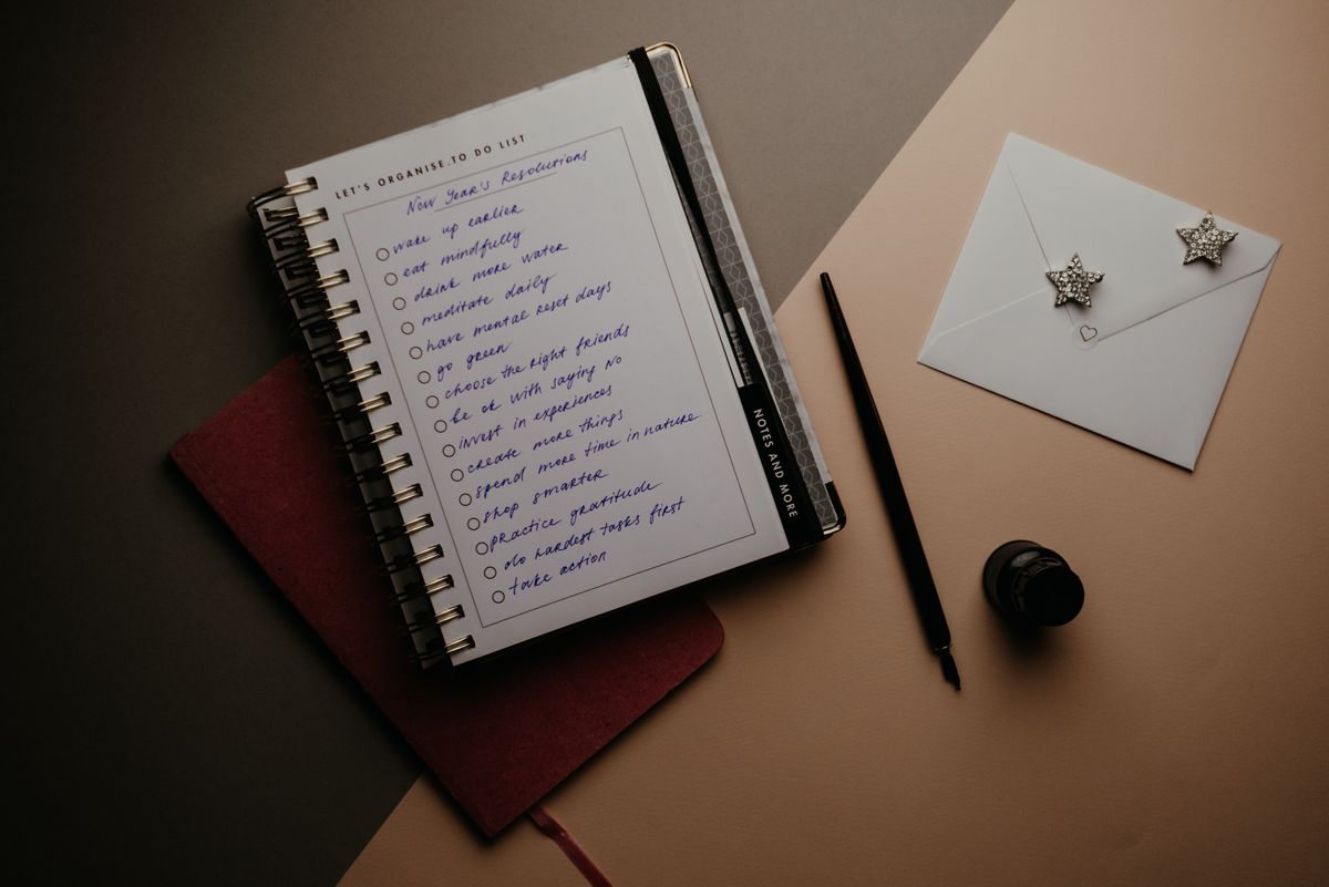 Open notebook with a handwritten checklist on a desk