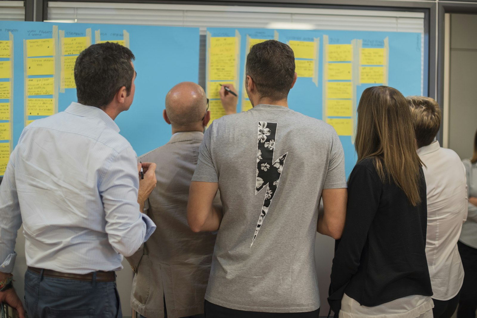 Team members reviewing a project board covered in task cards